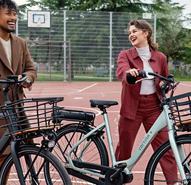 man en vrouw met fiets op een basketbalveld