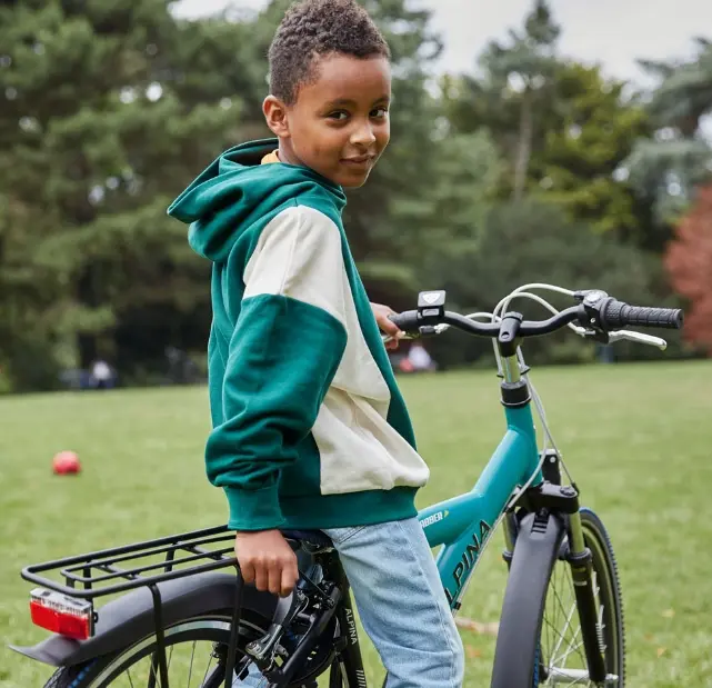 jongen op alpina fiets in een park